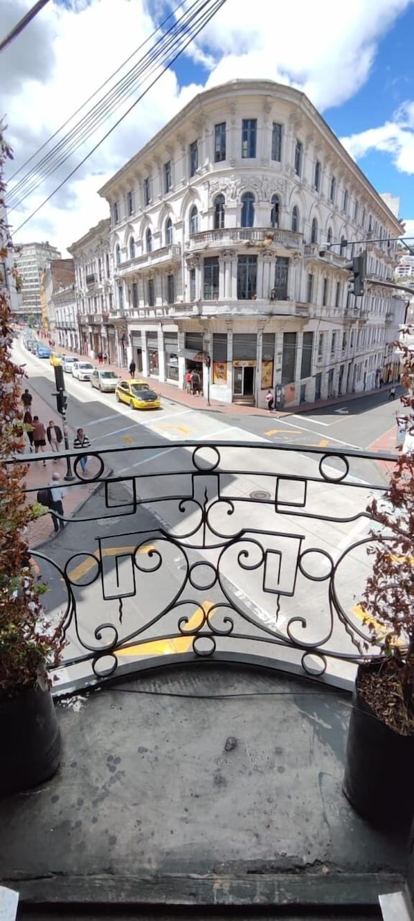 A view of a street with a large, ornate building in the background.