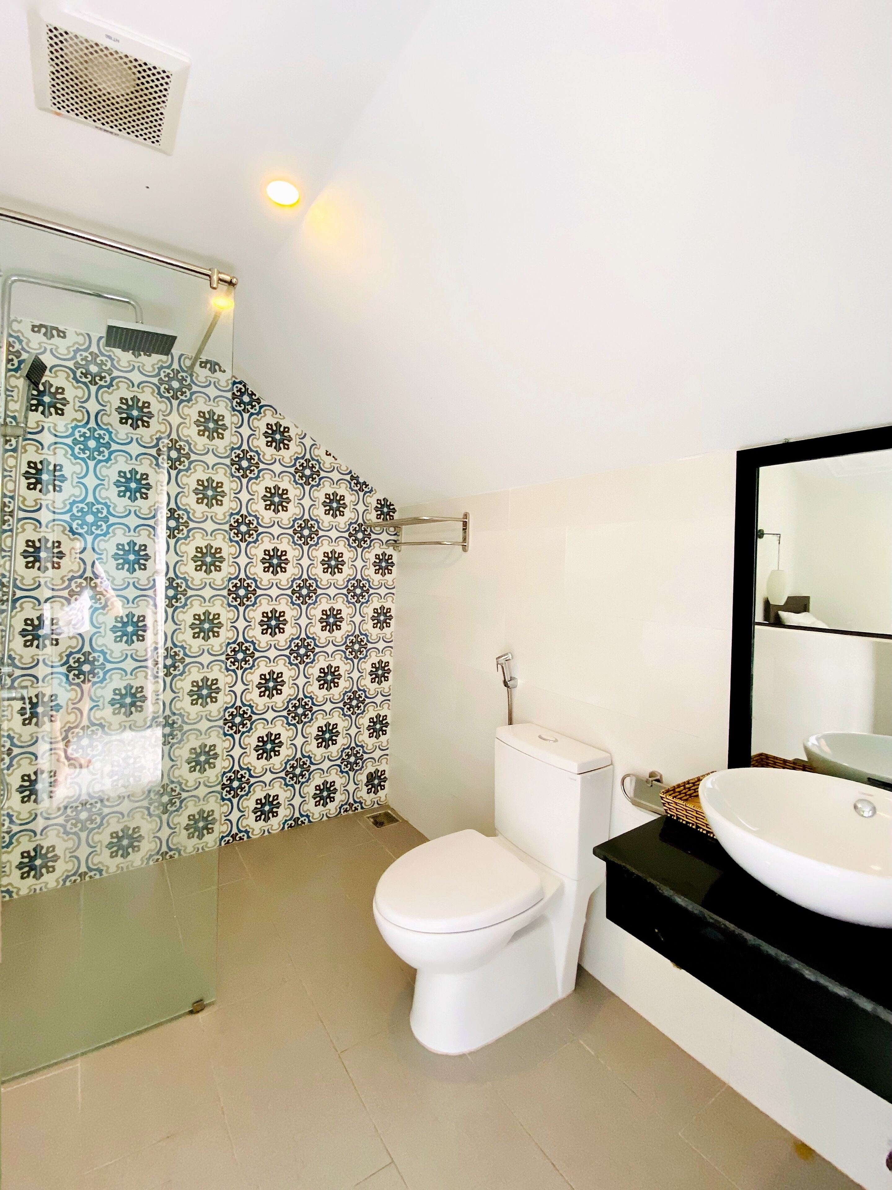 A bathroom with a shower, toilet, and sink.