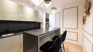 A modern kitchen with a central island, black chairs, and pendant lighting. - Beaubois, 2BR/3BA, 6 people (París)