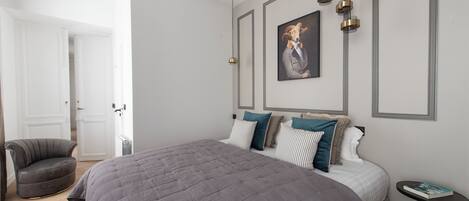 Una camera da letto con un letto grande, una sedia e un tavolino.