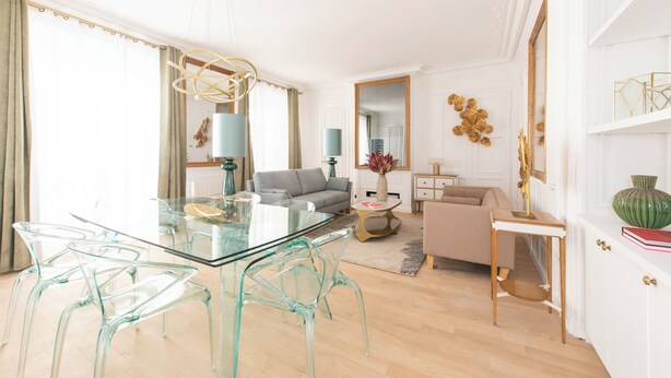 A modern living room with a glass dining table, clear chairs, a grey sofa, and a beige armchair. - Beaubois, 2BR/3BA, 6 people (París)