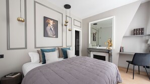 A modern bedroom with a large bed, a fireplace, a mirror, and a desk. - Beaubois, 2BR/3BA, 6 people (París)