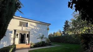 A modern two-story house with a well-maintained lawn and a pathway leading to the entrance.