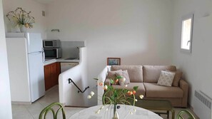 Cozy living space with a kitchenette, sofa, and small table.
