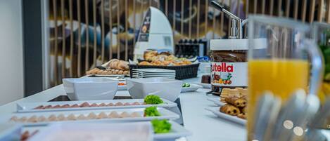 Una mesa de buffet con diferentes alimentos y una máquina de café.
