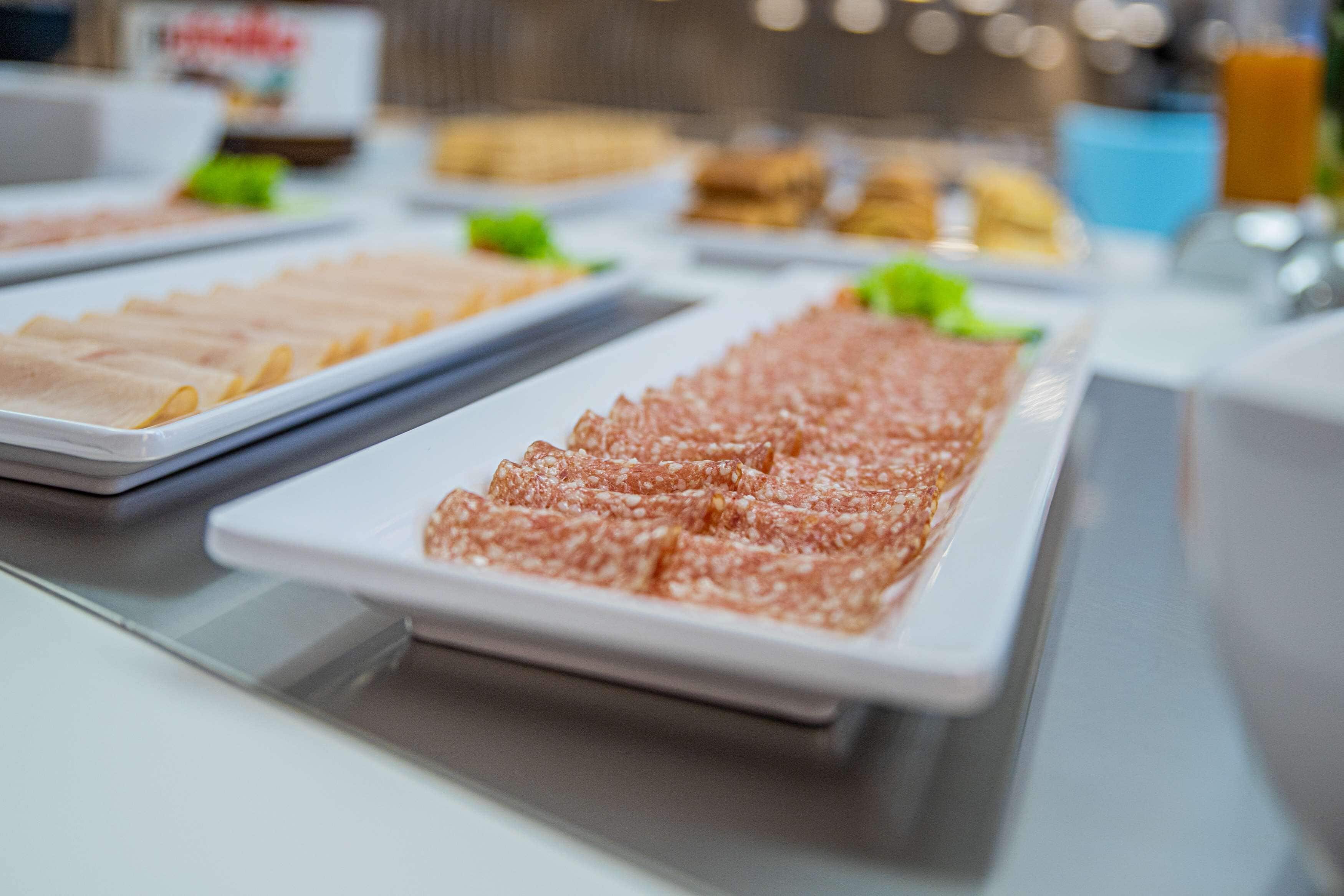 A buffet with various food items, including sliced meats and vegetables.