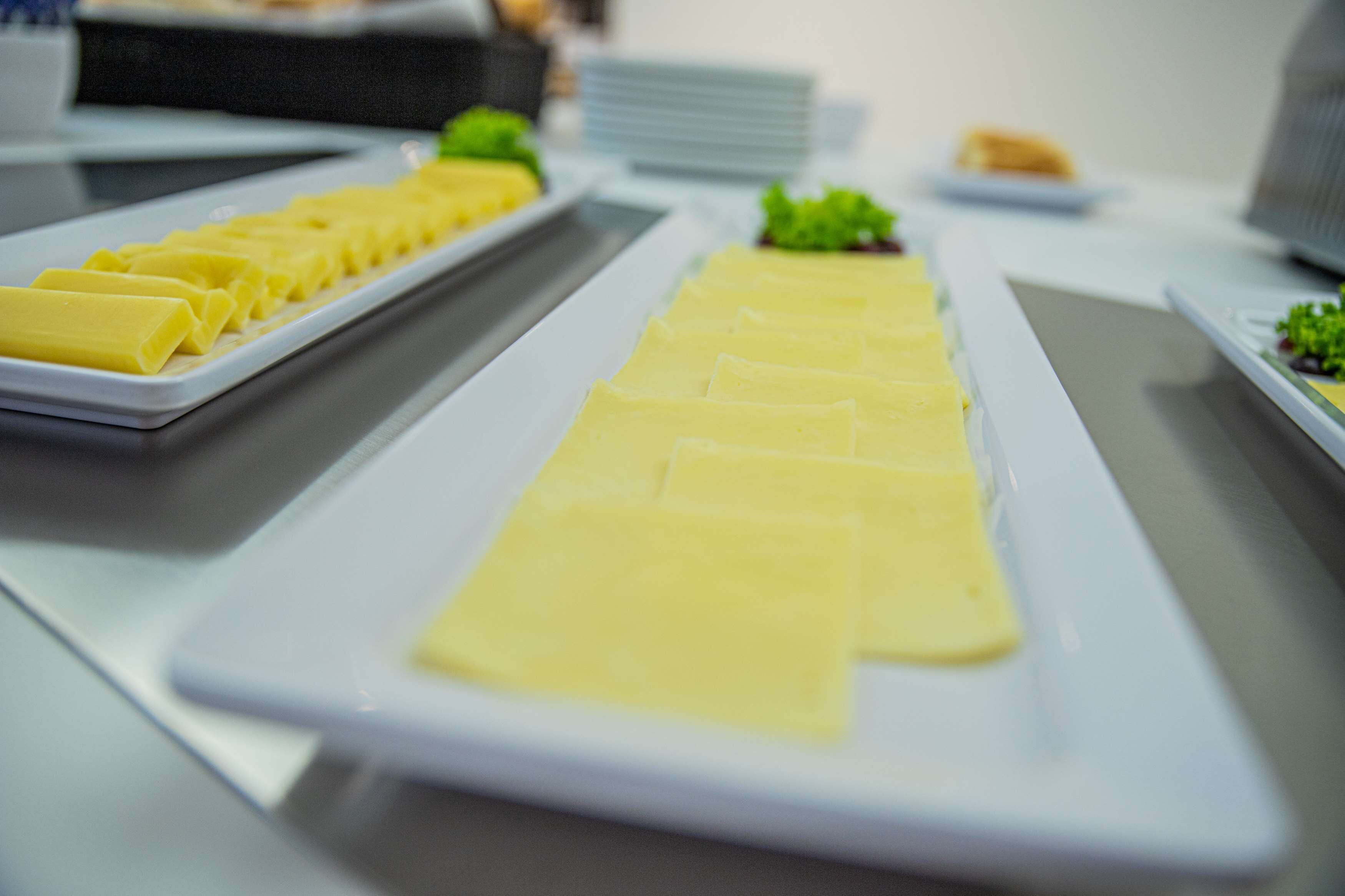 Una mesa de buffet con rebanadas de queso rectangulares dispuestas ordenadamente.