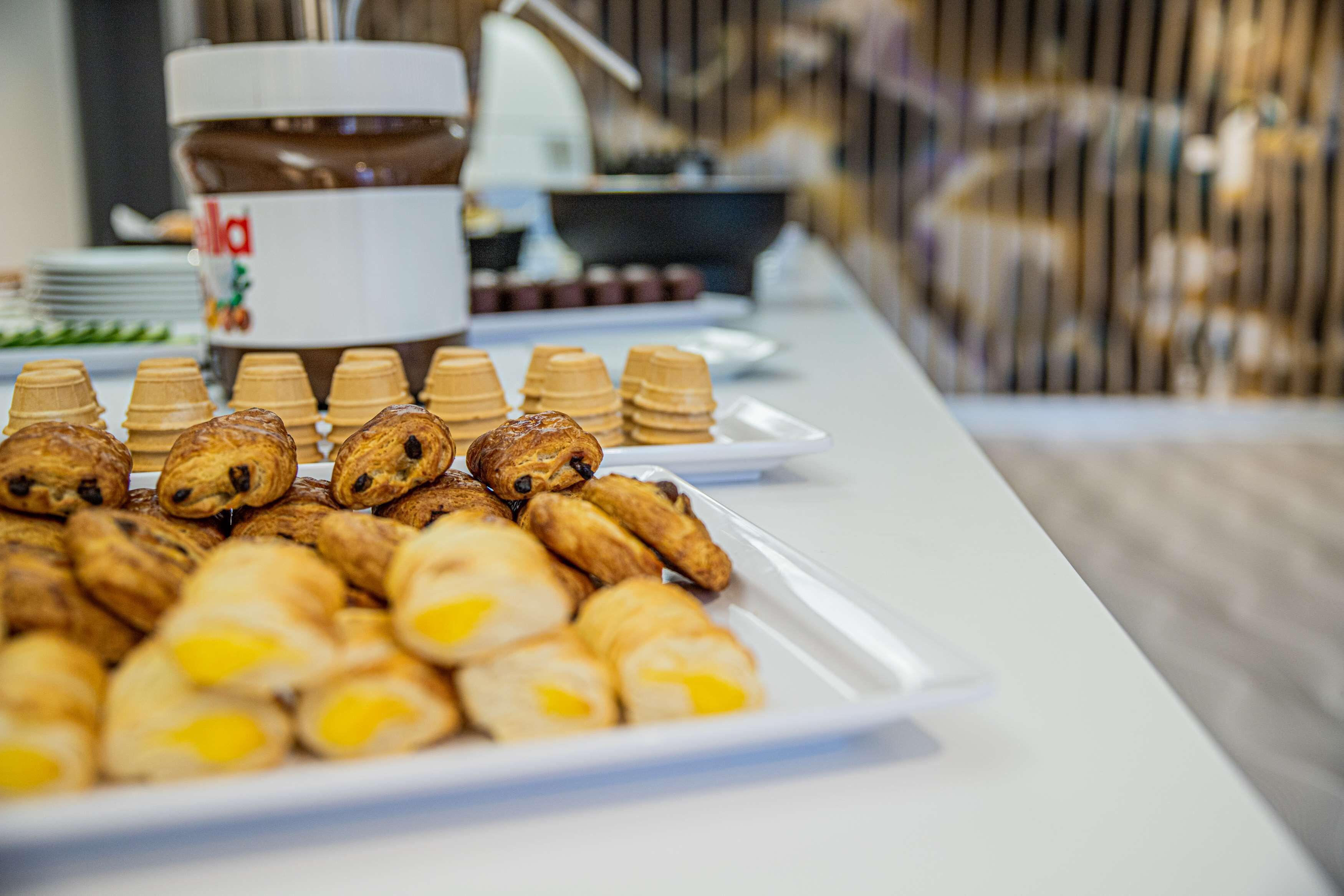 Une table de buffet avec divers pâtisseries et un pot de beurre de cacahuète.