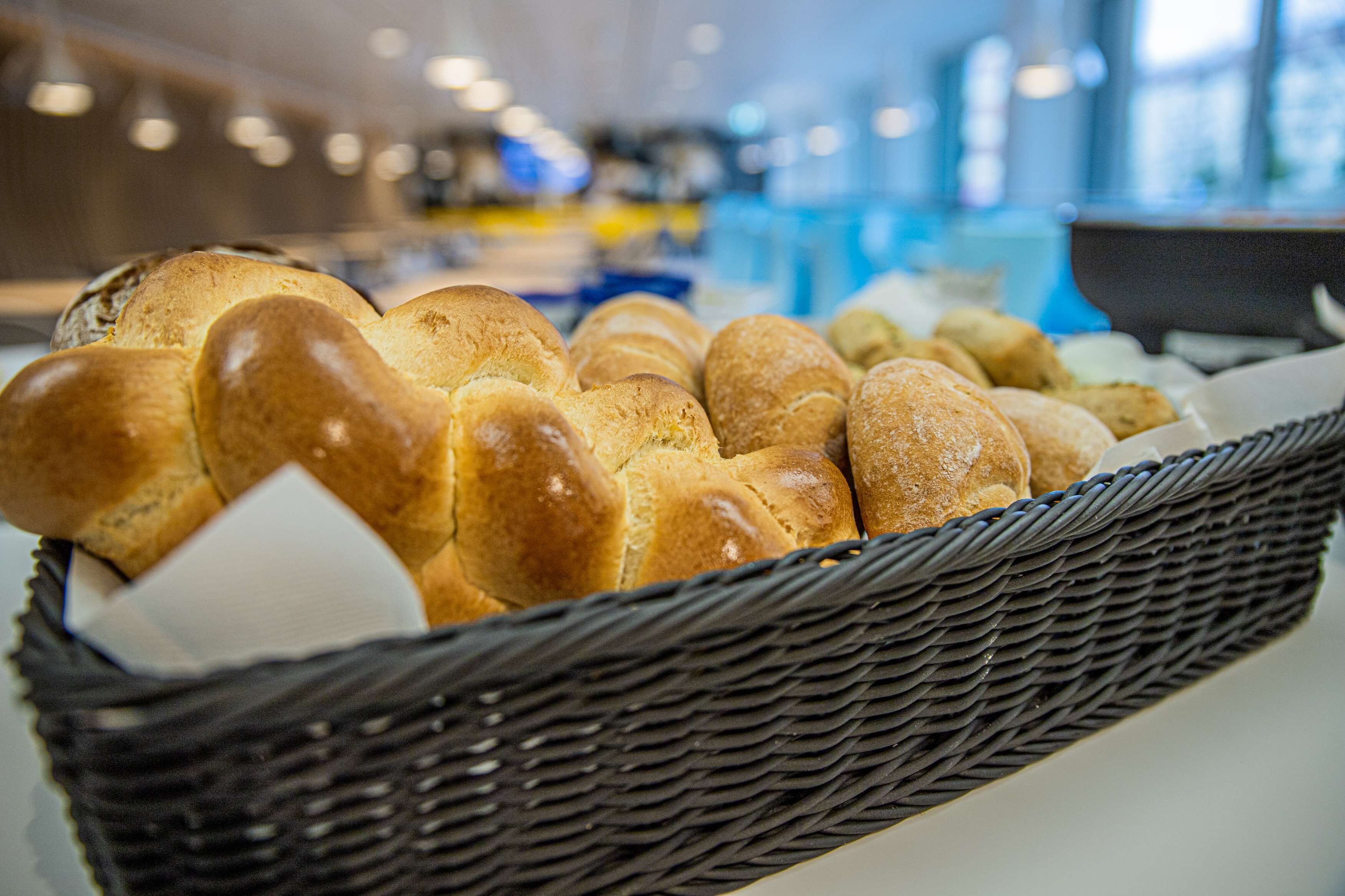 A basket of freshly baked bread in a bakery setting.