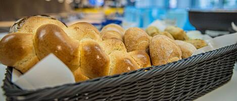 A basket of freshly baked bread in a bakery setting.