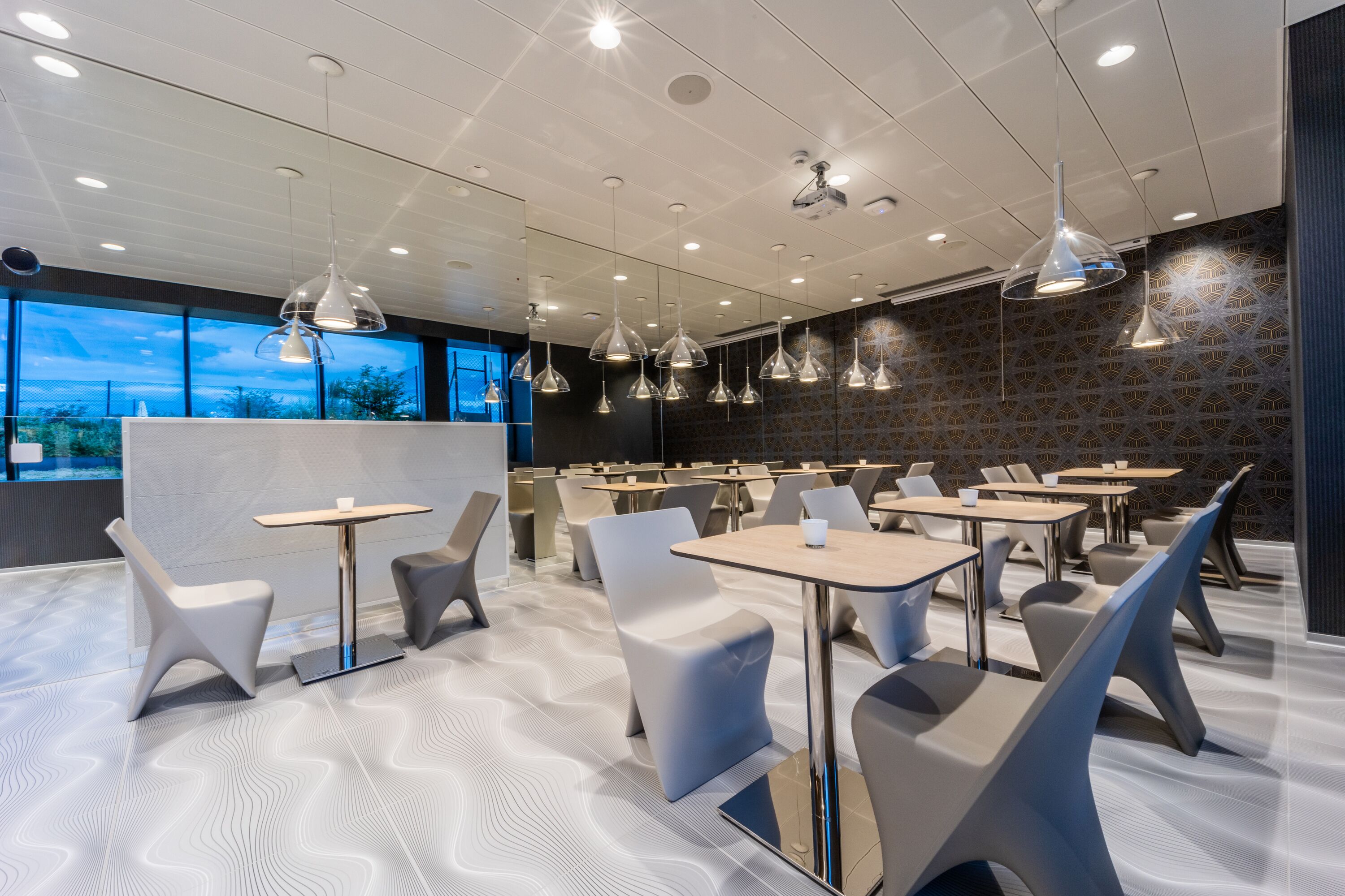 A modern dining area with contemporary furniture and pendant lighting.