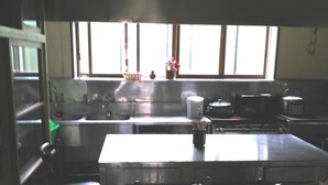 A kitchen with a large island, chairs, a sink, and a window.