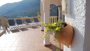 Ein Balkon mit Stühlen und einer Topfpflanze.