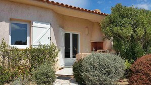 A house with a white door, a window, and a small outdoor area with plants. - Mini-villa No. 10 - 2/4 people (Porto-Vecchio)