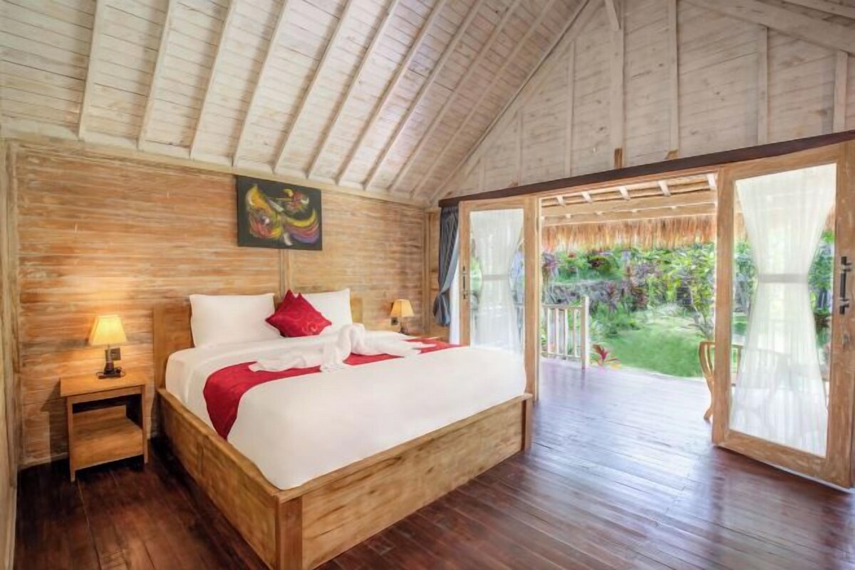 A wooden-framed bedroom with a bed, nightstands, and a large window.