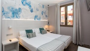 A double bed with white and grey bedding, a nightstand with a lamp, and a wall with abstract blue artwork. - Hostal Opera Ramblas (Barcelona)