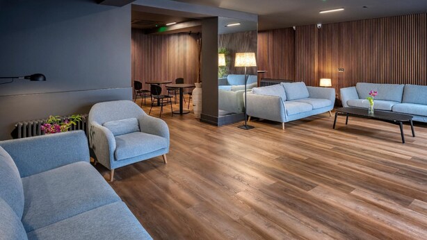 A modern living room with grey sofas, a coffee table, and a wooden floor. - Hostal Opera Ramblas (Barcelona)