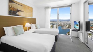 A hotel room with two beds, a TV, and a large window with a city view. - Chevron Renaissance Ocean & River Views (Surfers Paradise)