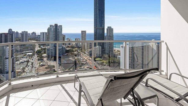 A balcony with a city view, including high-rise buildings and a clear sky. - Chevron Renaissance Ocean & River Views (Surfers Paradise)
