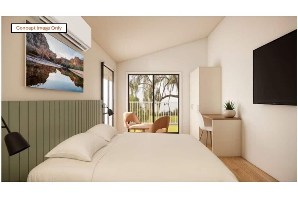 Une chambre à coucher comprenant un lit, un bureau, une chaise et une fenêtre donnant sur l’extérieur.