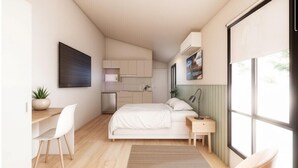 Una habitación compacta con cama, mesita de noche, silla, escritorio y una pequeña kitchenette.