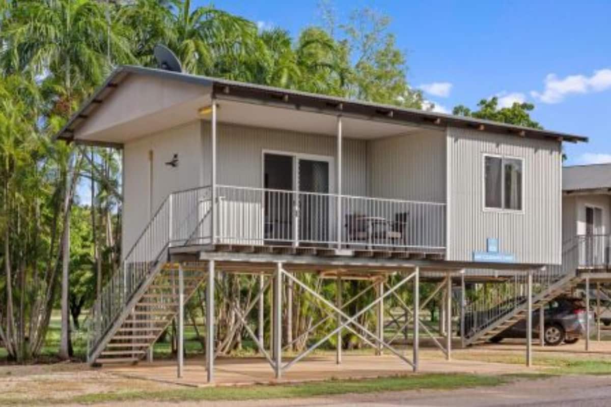 Un immeuble de deux étages doté d’un balcon et d’un escalier menant à l’étage supérieur.