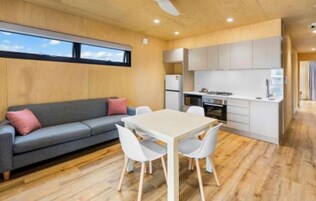 A compact living space with a sofa, dining table, and kitchenette.