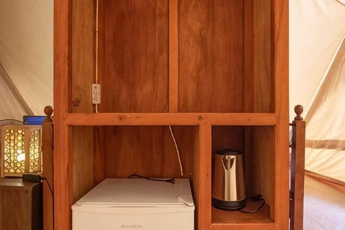 Ein Holzschrank mit einem weißen Gerät und einem schwarzen Behälter darin.