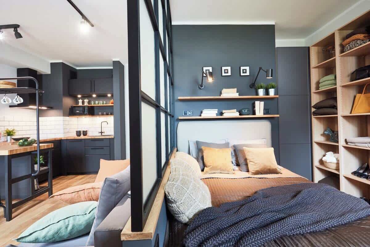 A modern bedroom with a large bed, bedside tables, and a built-in wardrobe.