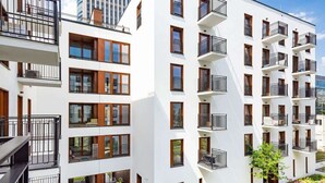 A modern multi-story residential building with balconies, large windows, and a flat roof. - Modern Apartment with Balcony | Close to the Metro (Warszawa)
