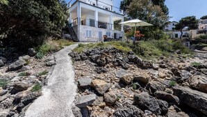 Un edificio moderno con un sendero de piedra que conduce a una entrada blanca.