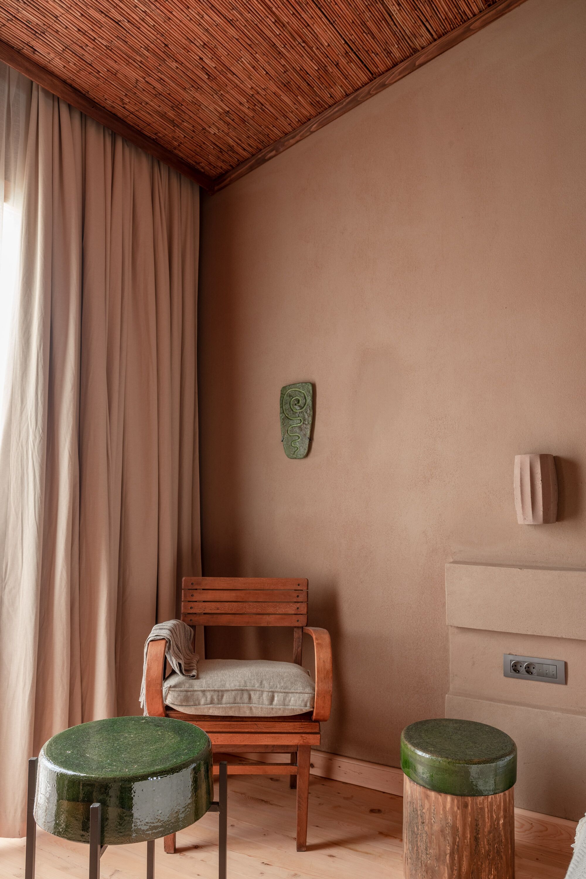 Une pièce comprenant une chaise en bois, une petite table ronde et un tabouret en bois.