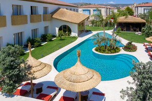 Una piscina al aire libre de temporada, sombrillas