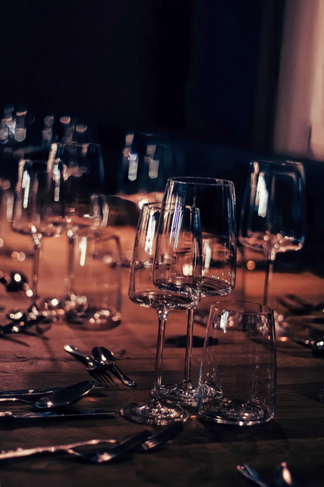 A table set with multiple wine glasses and cutlery, suggesting a dining arrangement.