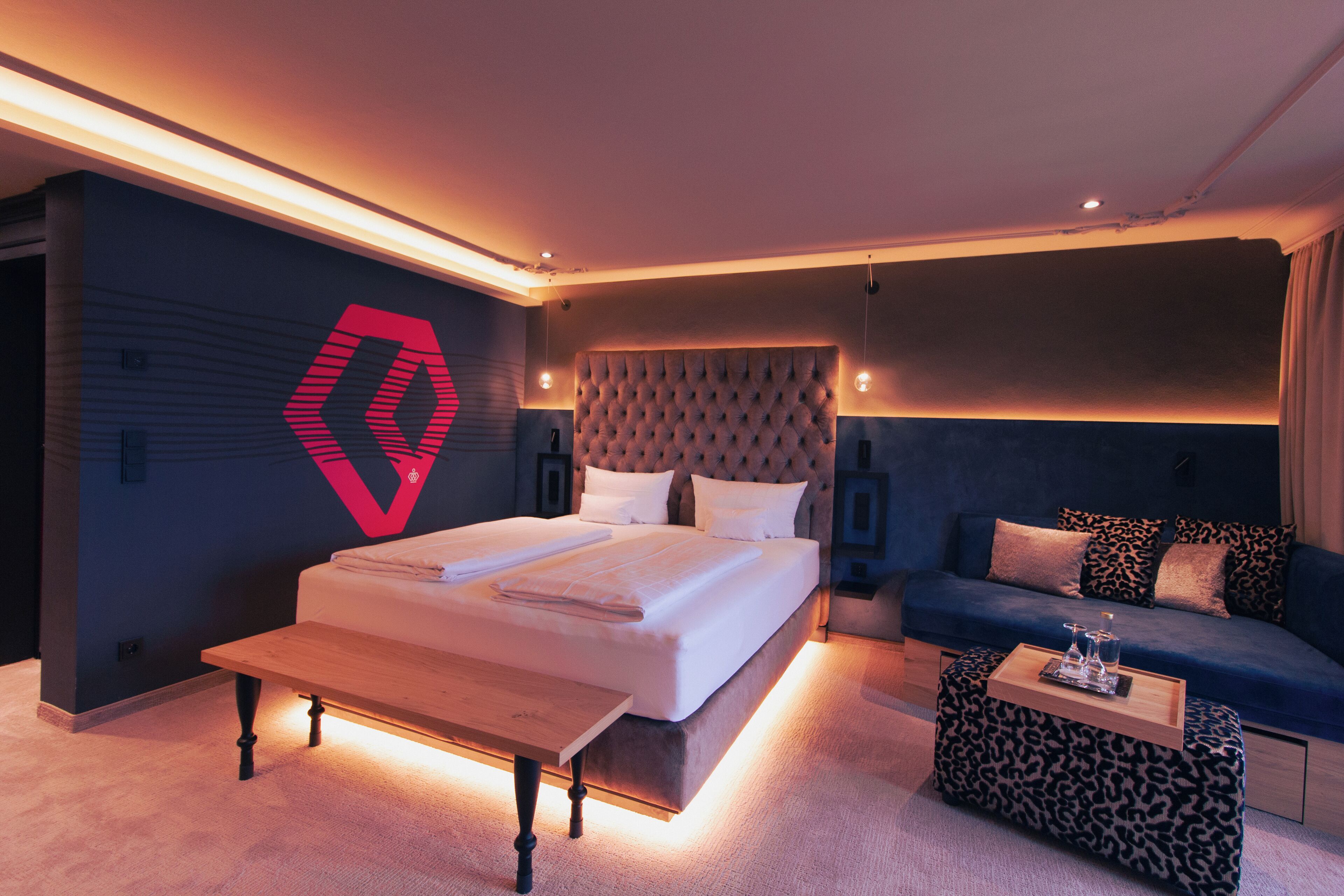 Un dormitorio moderno con una cama grande, un sofá y una pequeña mesa.
