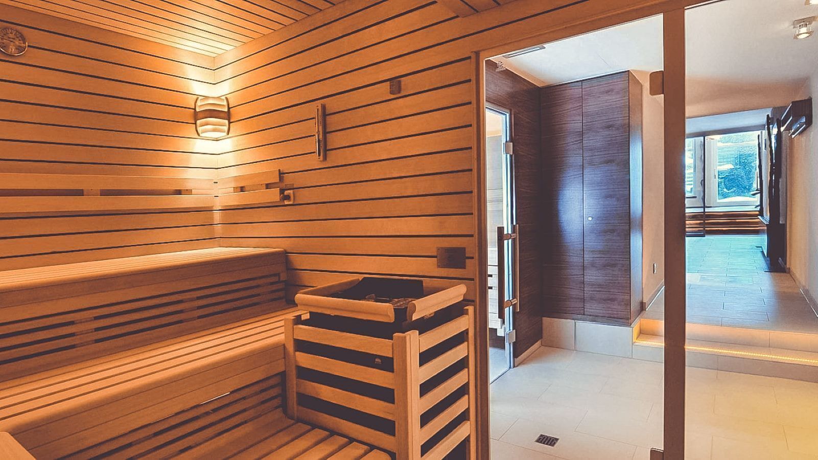 A sauna with wooden benches and a bench with a sink.