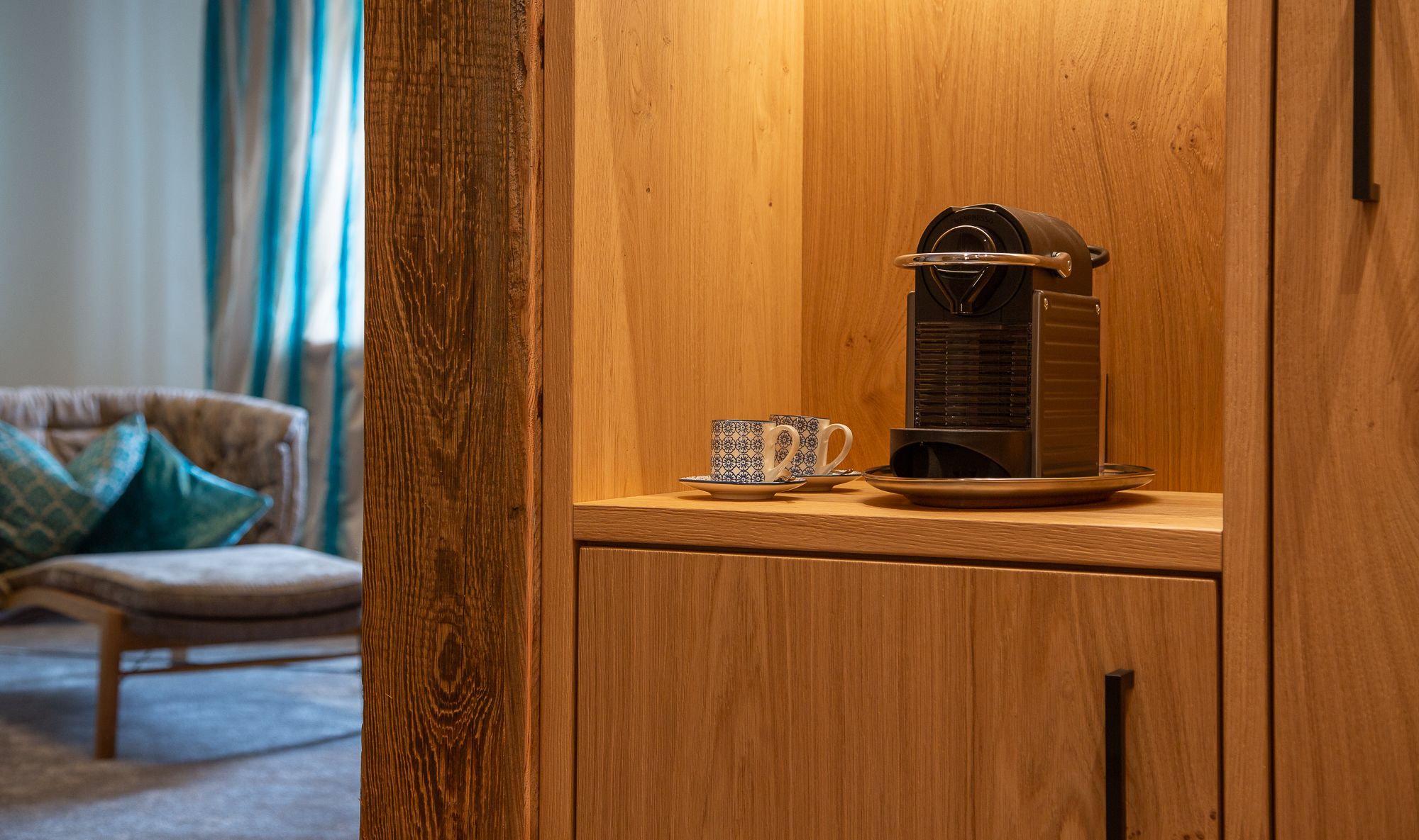 Un meuble en bois contenant une machine à café et une tasse sur un plateau.
