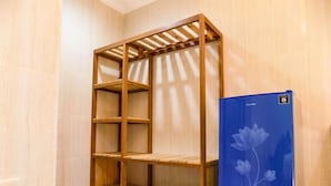 A room with a wooden shelving unit and a blue refrigerator. - Guna Graha Kuta (Kuta)