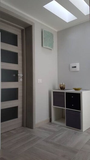 Enter a clean and contemporary space with an entrance, console table, and herringbone floor.
