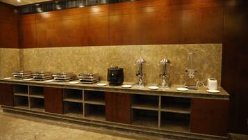 A buffet setup with various food items and appliances.