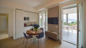 Una cocina moderna con comedor, televisor de pantalla plana y vistas al exterior.