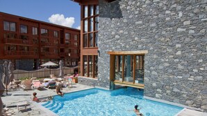 Un espace piscine avec des chaises longues et un bâtiment en pierre.