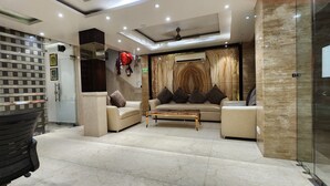 A modern lobby with a sofa set, a coffee table, and a glass partition. - TG Tashkent Hotel (New Delhi)