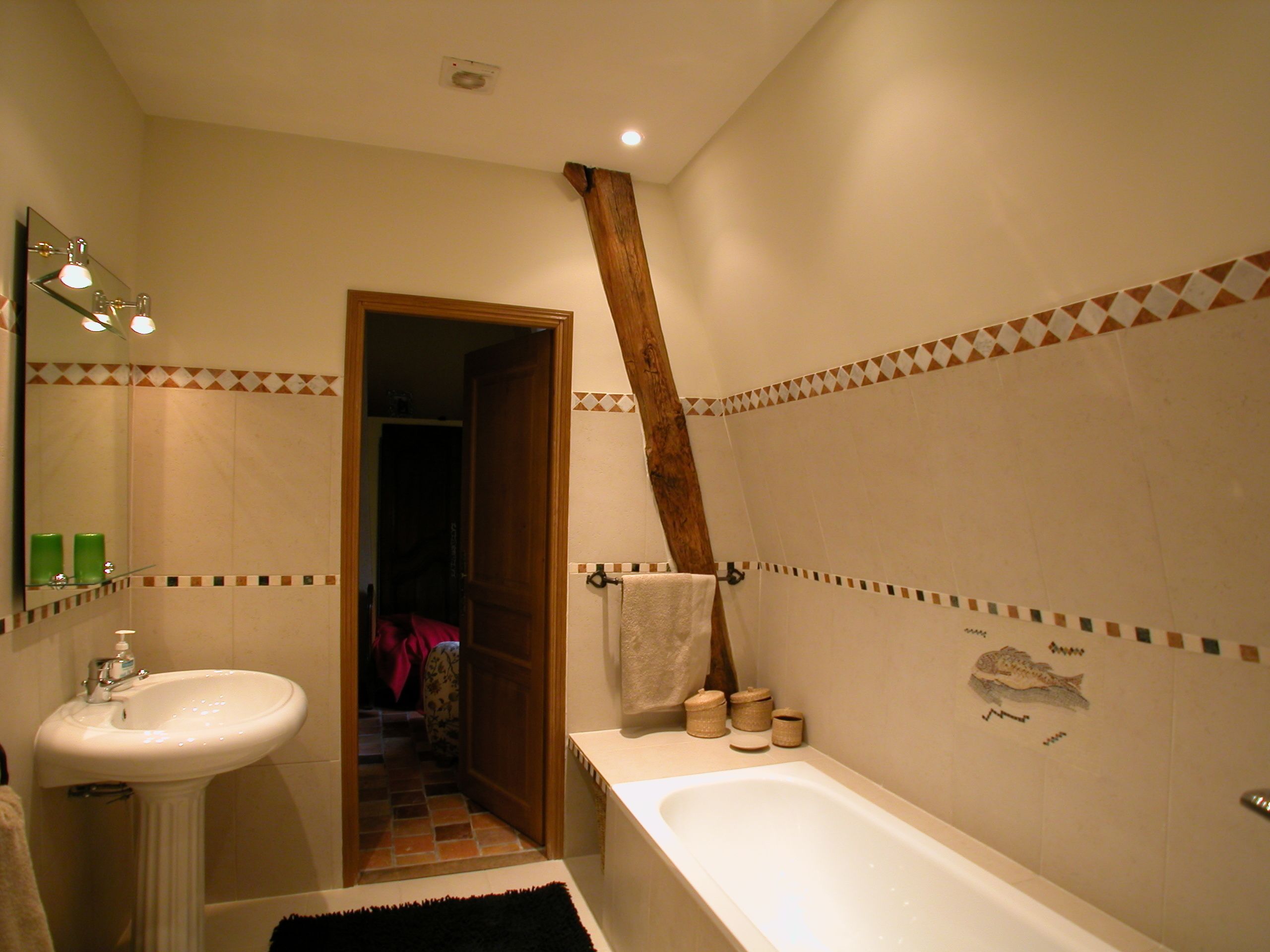 Un baño con lavamanos, bañera y espejo.