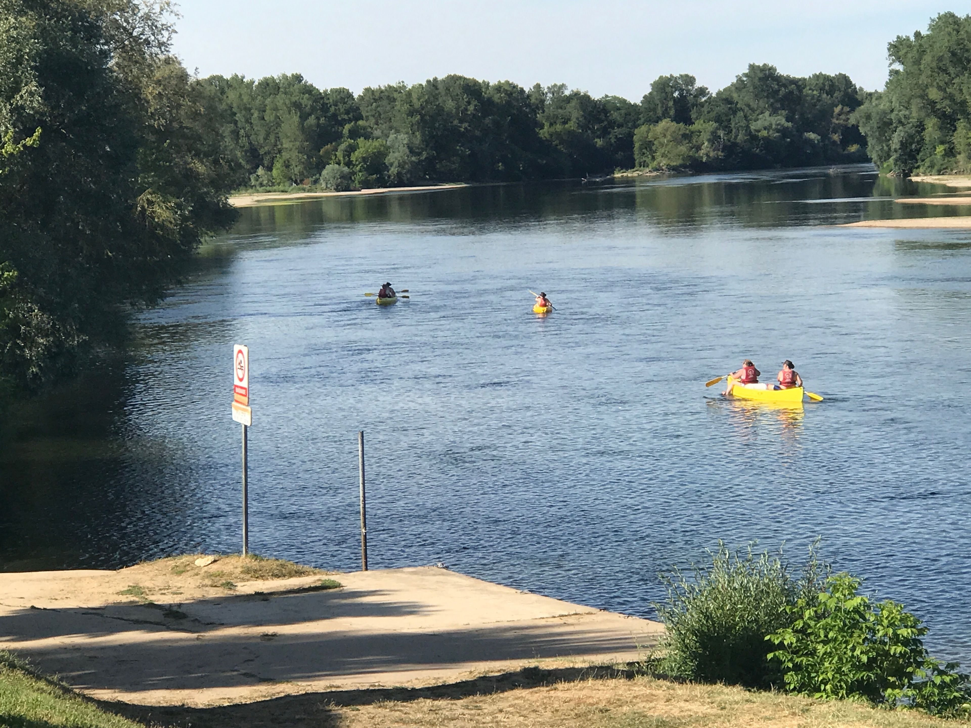 Une rivière paisible où l’on peut faire du kayak et du canoë, bordée d’une forêt dense.