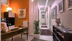 A hallway with a desk, computer, and a potted plant. - La Collina dei Ciliegi (Salerno)