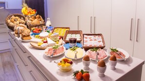 A buffet table with various food items including bread, cheese, meats, and fruits. - Sable d'O (Ostend)