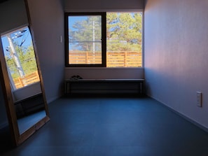 Una habitación con un ventanal grande, un banco y una puerta.