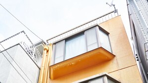 Un edificio a più piani con facciata gialla, ampie finestre e un ingresso garage ben visibile.
