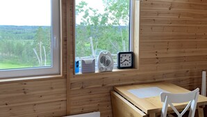A wooden cabin room with a desk, chair, and a window overlooking a forest. - Stuga på Nässjö Golfklubb (Nassjo)